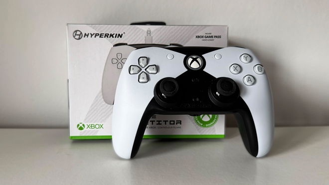 White and black Xbox-branded controller in front of its weight box with green trim.
