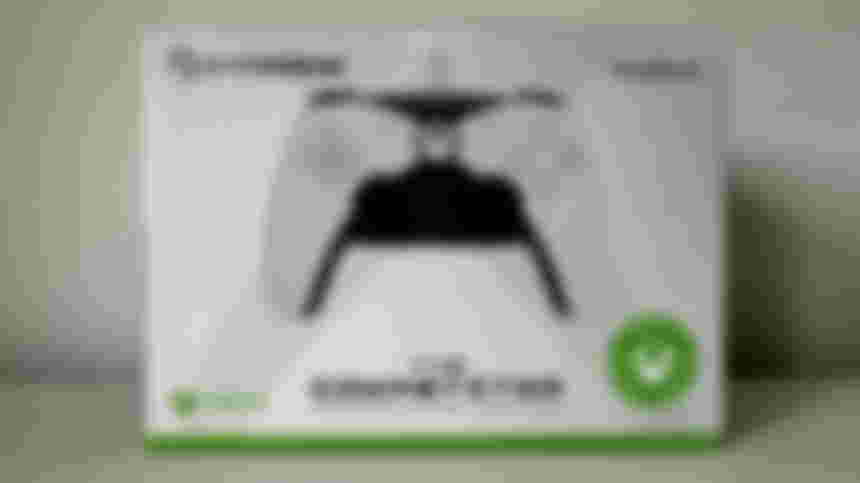 White box with green trim and an image of a white and black controller on it.