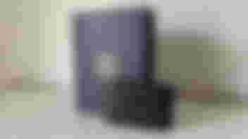 A black Elgato capture card leaning against a blue box with the Elgato logo in white in the center.